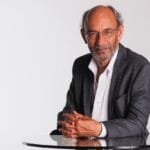 mentor, gray blazer, white shirt, professional, male, corporate portrait, glasses, indian, thin, business executive, consultant, middle-aged, balding, glass table, folding hands, ceo, beard, thinking, ceo, ceo, ceo, ceo, ceo